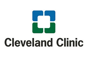The image shows the Cleveland Clinic logo featuring a stylized cross with blue and green squares. This represents a partnership with the Christopher Smith Foundation for caregiver support and disability advocacy.| A Non Profit For Caregivers | Christopher Smith Foundation