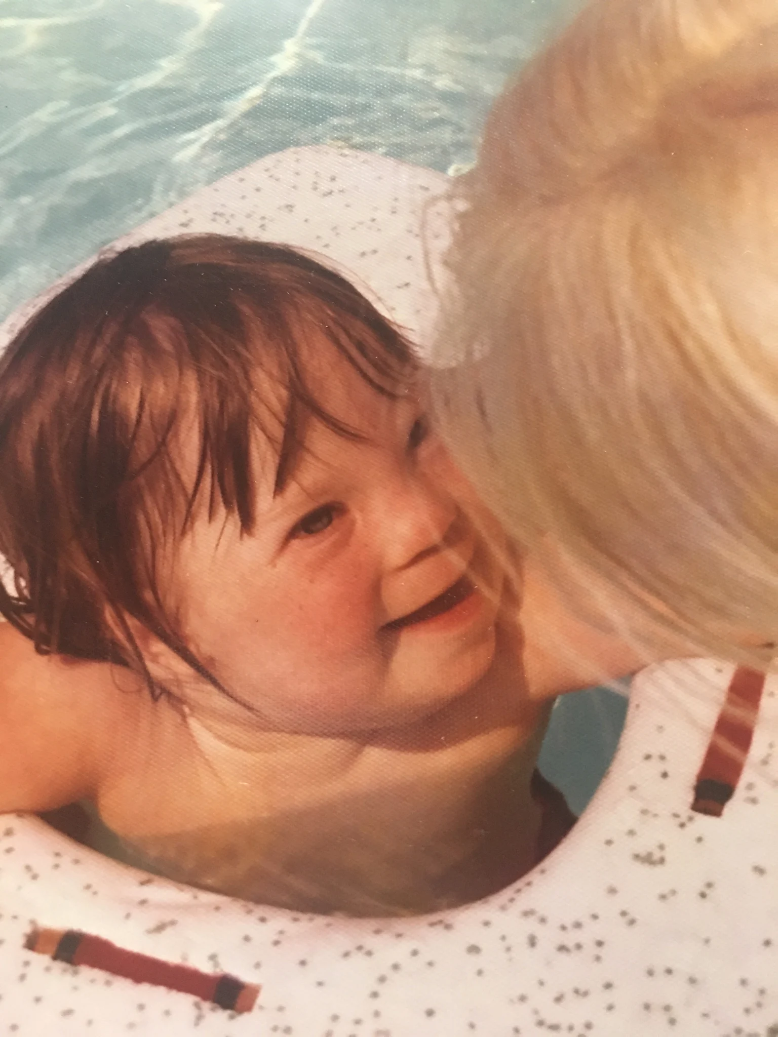 A child with brown hair smiles while in a pool, hugged by a caregiver. This image embodies the Christopher Smith Foundation's mission of caregiver support and recognition within the disability community.| A Non Profit For Caregivers | Christopher Smith Foundation