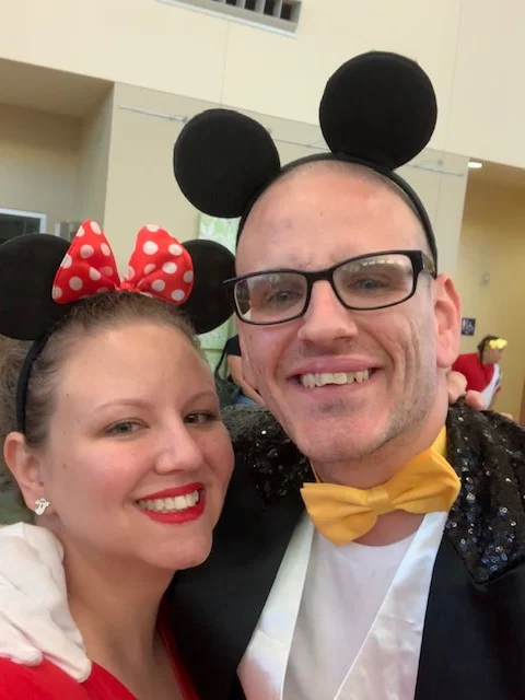 A smiling couple dressed in Mickey and Minnie Mouse costumes at a Christopher Smith Foundation event, highlighting caregiver recognition and support for caregivers of people with disabilities, fostering a sense of community and joy.| A Non Profit For Caregivers | Christopher Smith Foundation