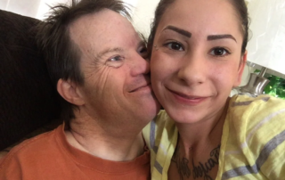 A woman in a yellow shirt smiles warmly with a man in an orange shirt, highlighting caregiver support within the disability community, as emphasized by the Christopher Smith Foundation's mission of gratitude and advocacy.| A Non Profit For Caregivers | Christopher Smith Foundation