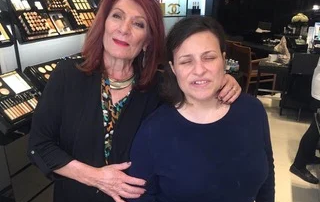 Two women stand in a makeup store; the older woman embraces the younger, both smiling. This scene highlights caregiver support and community, reflecting the Christopher…| A Non Profit For Caregivers | Christopher Smith Foundation