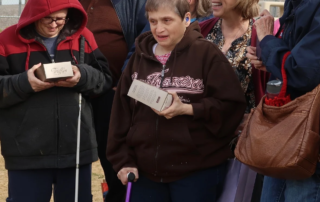 A group of smiling people, some holding boxes of truffles, gather outdoors, highlighting joy and community. This reflects the Christopher Smith Foundation's mission of caregiver support and recognition within the disability community.| A Non Profit For Caregivers | Christopher Smith Foundation