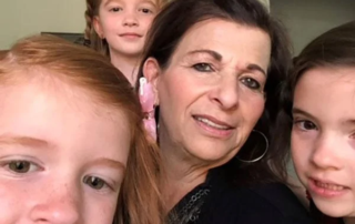 A caregiver smiles warmly with three young children, highlighting caregiver support and the nurturing environment fostered by the Christopher Smith Foundation for family caregivers and the disability community.| A Non Profit For Caregivers | Christopher Smith Foundation