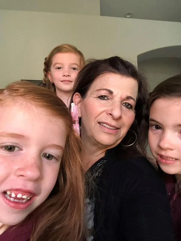 A caregiver smiles warmly with three young children, highlighting caregiver support and the nurturing environment fostered by the Christopher Smith Foundation for family caregivers and the disability community.| A Non Profit For Caregivers | Christopher Smith Foundation