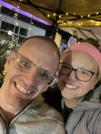 Two people smiling warmly under string lights, highlighting caregiver support within the disability community. The image reflects the Christopher Smith Foundation’s mission to honor caregivers of people with disabilities.| A Non Profit For Caregivers | Christopher Smith Foundation