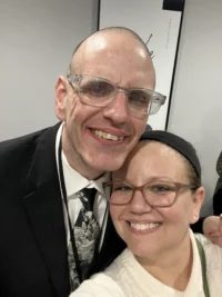 A man and woman smile closely for a photo at a Christopher Smith Foundation event, highlighting caregiver support and community through their joyful expressions and warm connection.| A Non Profit For Caregivers | Christopher Smith Foundation