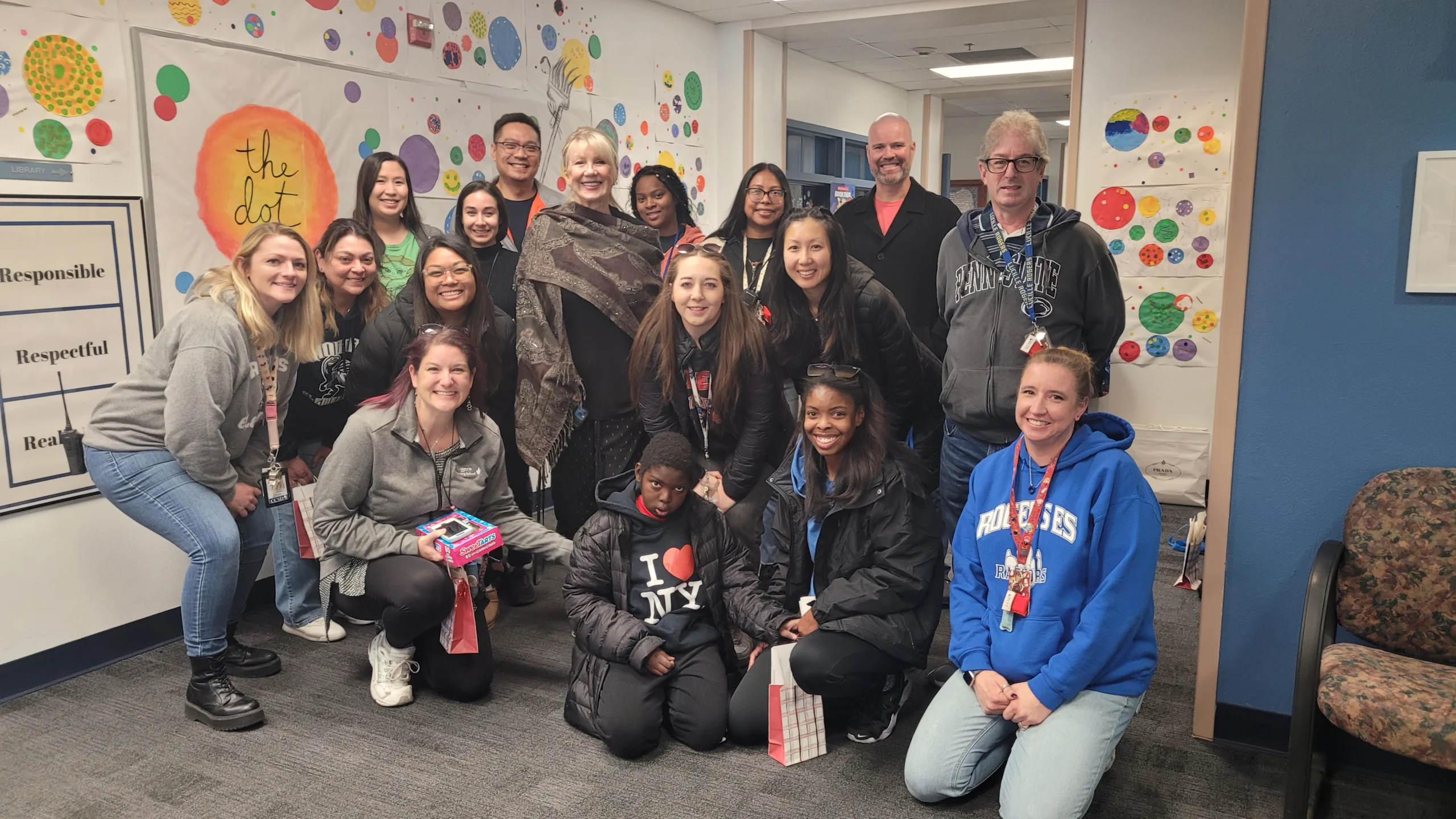 A diverse group of smiling people, including family caregivers and children, gather in a colorful room for a Christopher Smith Foundation event, highlighting caregiver support and community engagement.| A Non Profit For Caregivers | Christopher Smith Foundation